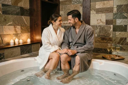 Couple en robes de bain au bord d'un spa privatif romantique à Toulouse avec bougies et champagne