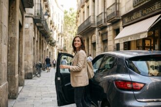 Femme sortant d'une petite citadine garée dans une rue pavée d'un centre-ville européen, sac en toile à la main, ambiance urbaine authentique