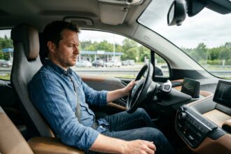 Homme au volant d'une voiture moderne sur l'autoroute